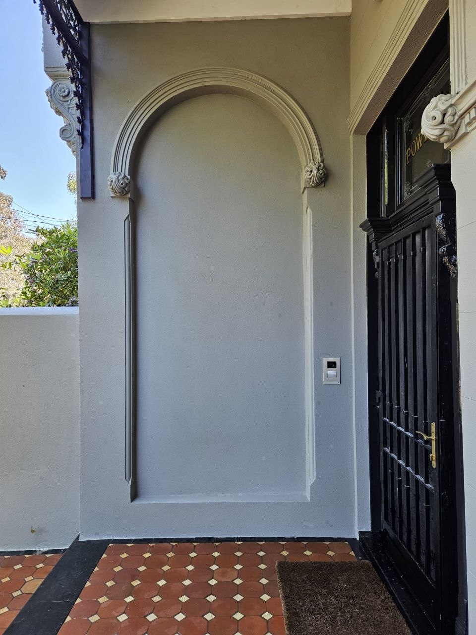 Restored arched render recess with moulded archivolt and scroll corbels at Brunswick