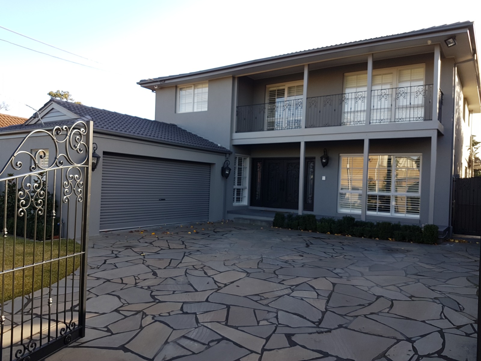 Completed rendered exterior of a two-storey brick veneer home in Essendon viewed from the front gate