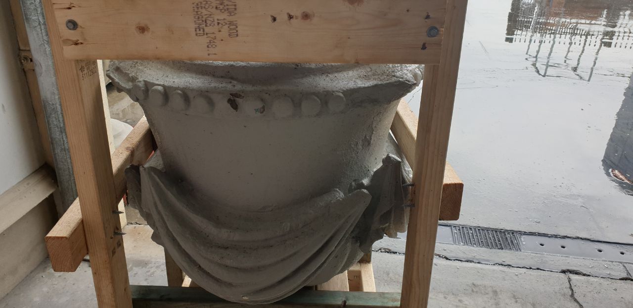 Original heritage urn supported in timber frame before removal