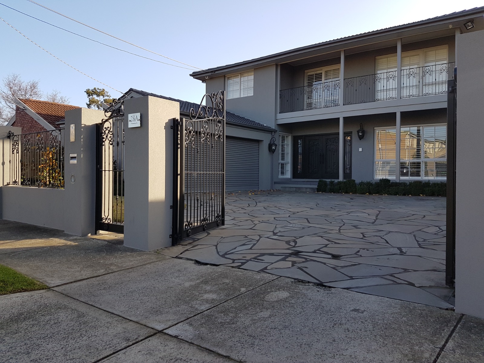 Rendered entry pillars and gate opening to a rendered brick veneer home in Essendon
