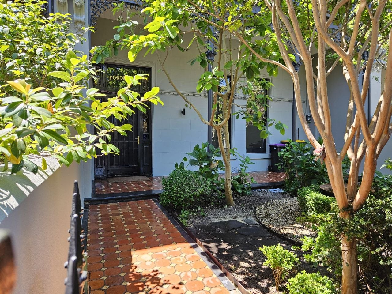 Restored Brunswick facade and tessellated entry path seen through the front garden