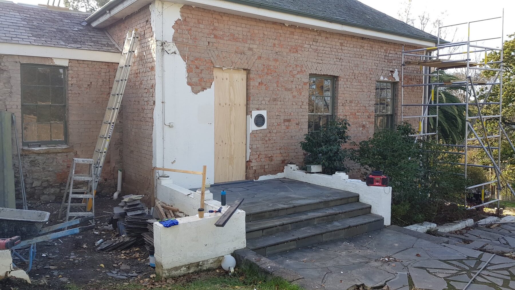 Failed render being stripped from the walls of Rosehill Homestead, Lower Plenty