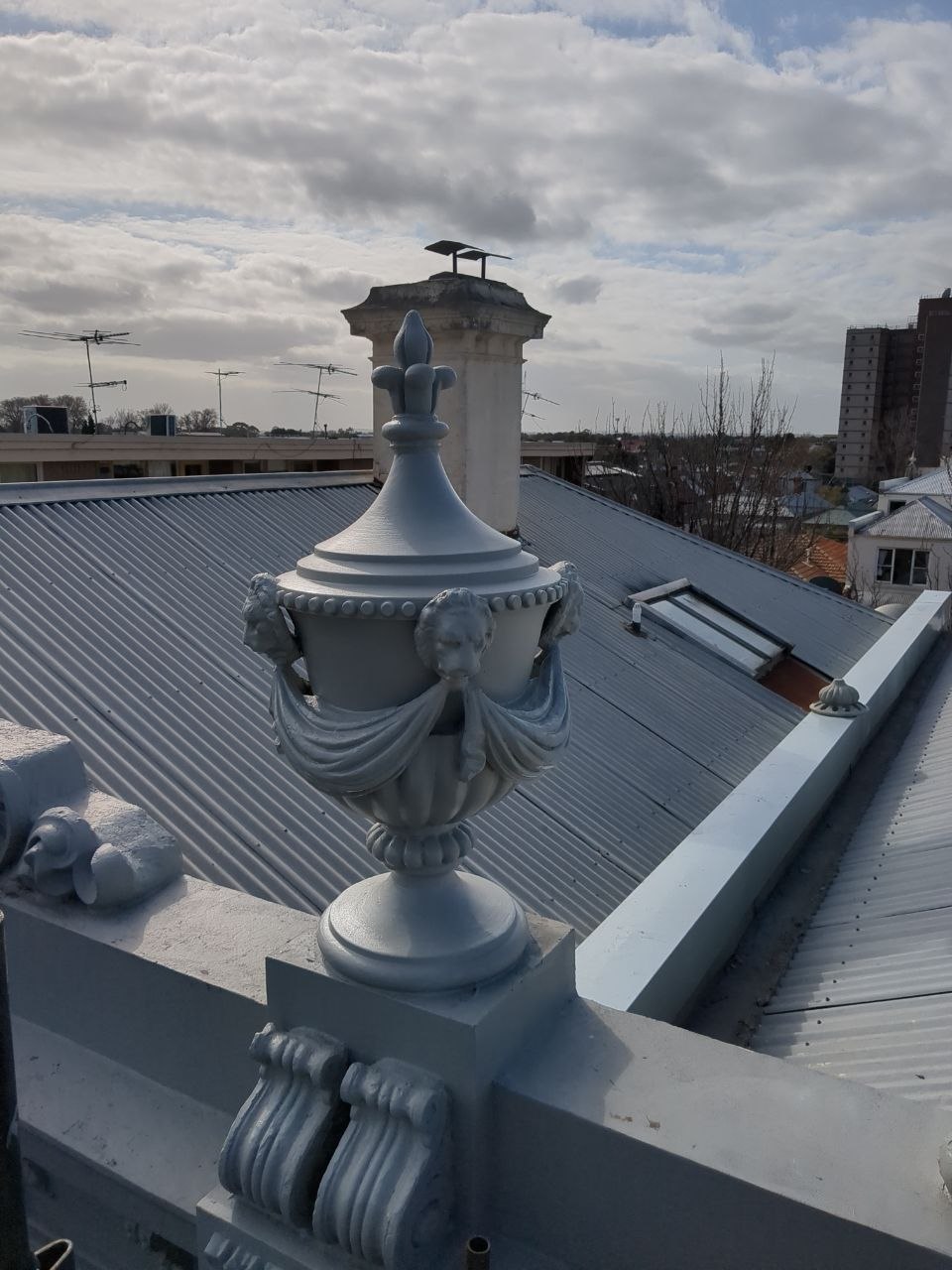 Recreated heritage urn installed on restored parapet
