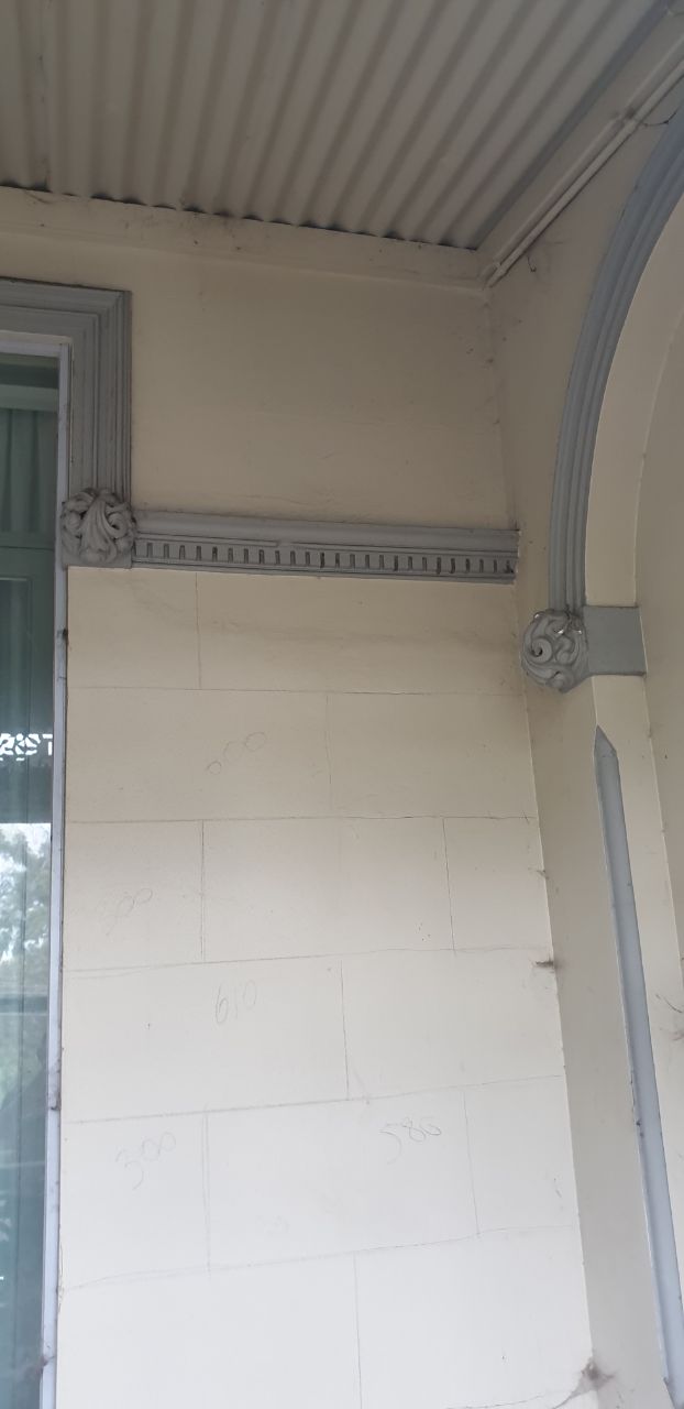 Set-out marks on the rebuilt Brunswick render beneath the restored dentil cornice before the finish coat