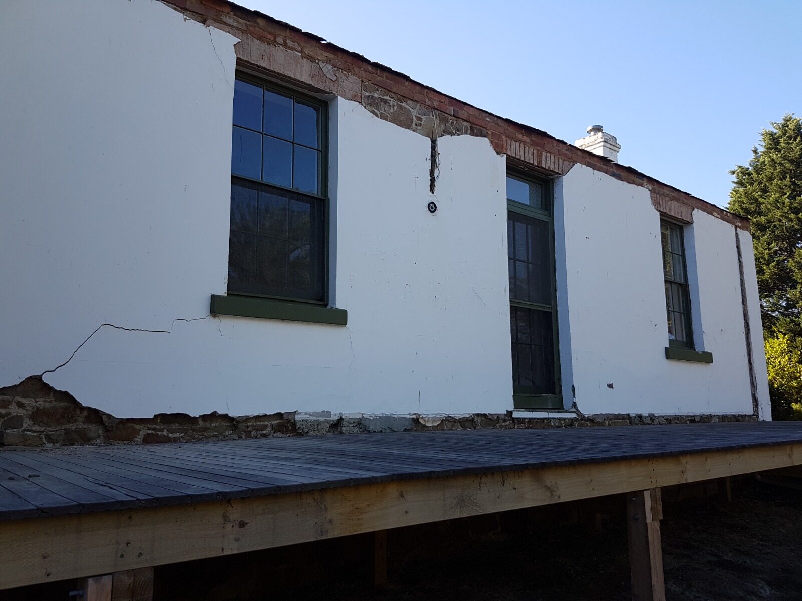 Failed render and deteriorated masonry at a wall head on Rosehill Homestead